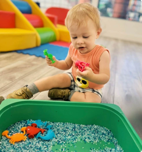 Infant exploring a sensory table