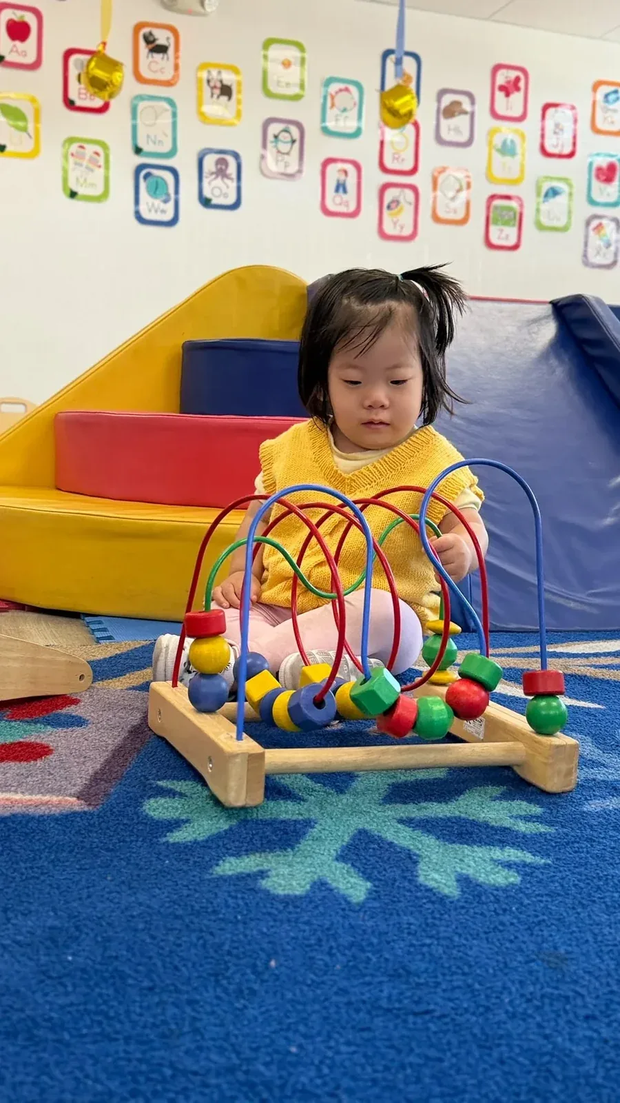 A baby playing with a bead maze toy