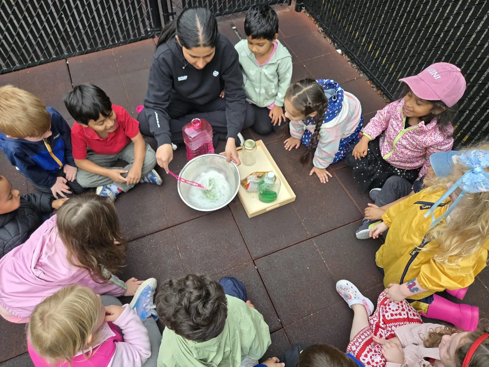 An educator leading a group of children in an outdoor science activity