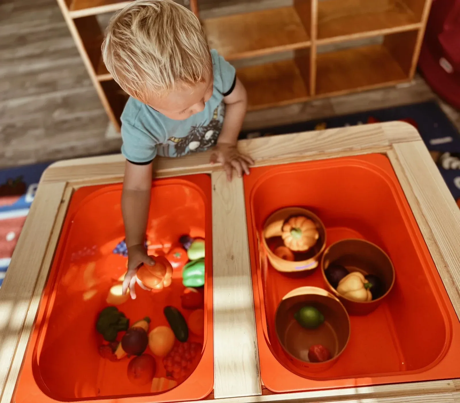 An infant exploring a sensory activity with an educator
