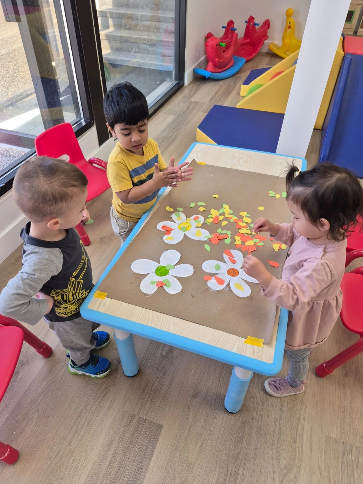 Toddlers engaged in collaborative play and communication while creating together