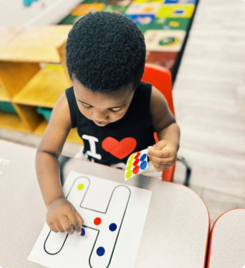 Toddler learning letters with colorful stickers